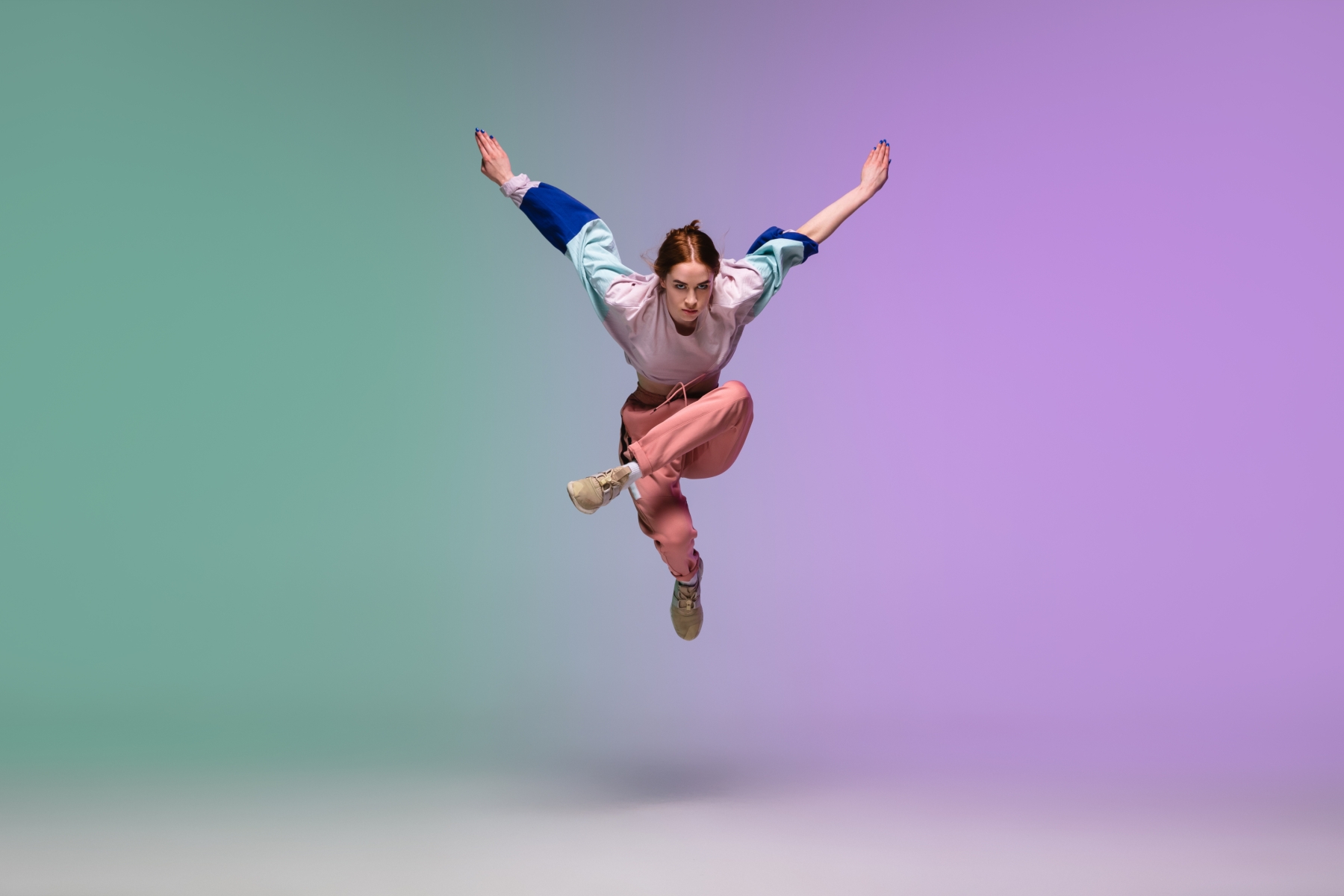 Kvinna som dansar i hiphop-stil med grön och lila bakgrund