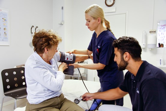 Patient får blodtrycket taget av vårdpersonal.