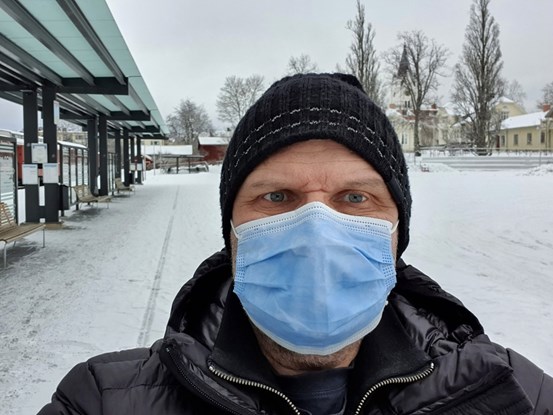 Man i munskydd utomhus under pandemin