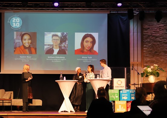 Bild från scenen på regionala utvecklingsdagen, en moderator intervjuar tre ungdomar vid ett ståbord