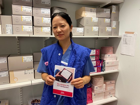 Anna Melkerhed, kontaktsjuksköterska stående i förråd med foldern Min vårdplan cancer