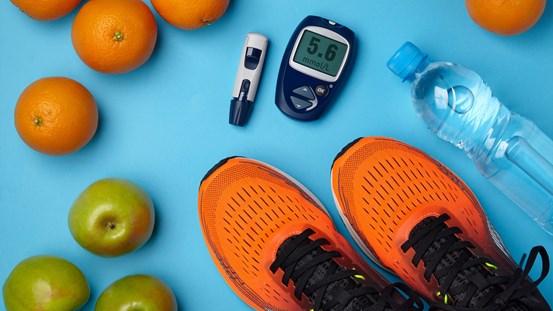 Detaljbild på frukter, träningsskor, vattenflaska och en diabetesmätare