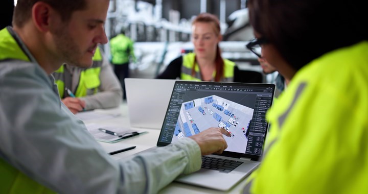 Personer i varselkläder arbetar tillsammans med en digital plan för logistik eller industri på en laptop