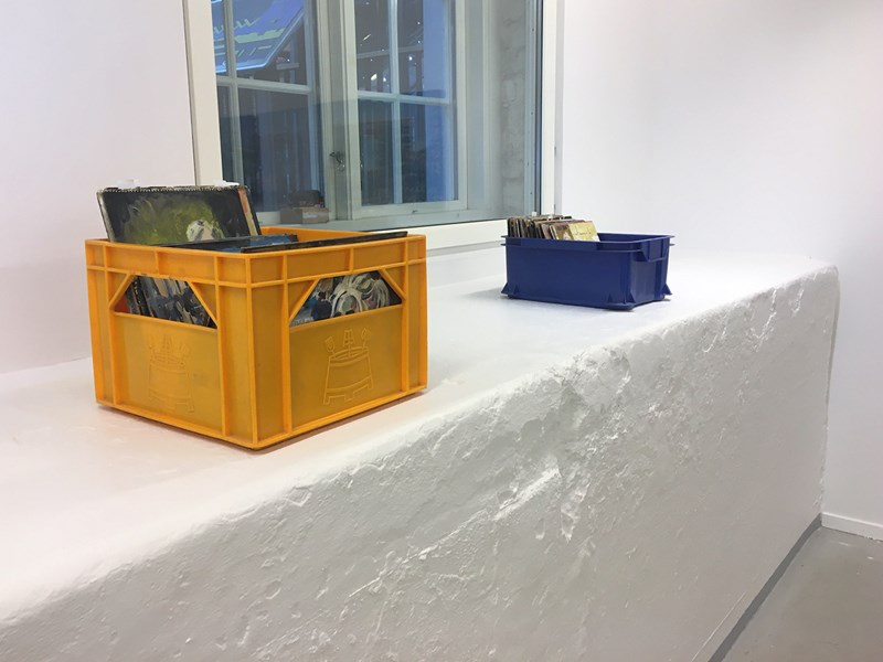 På den lilla upphöjningen längs in i galleriet, står två plastbackkar. I en gul och en blå skivback, återfinns fyrkantiga och rektangulära oljeskisser på papper, sorterade efter årgång, tillgängliga för publiken, som fritt kan bläddra bland dem.