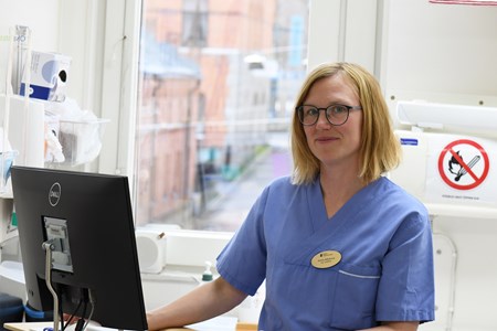 Tandläkare Kerstin framför sin dator i undersökningsrum. 