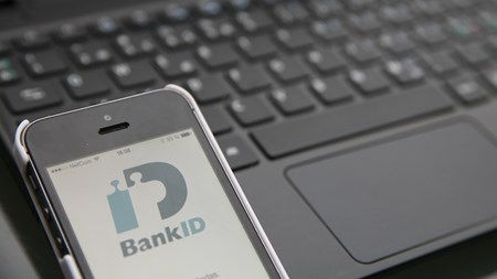 Mobil med bank-id ligger vid ett tangentbord redo att logga in via mobilen