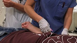 Undersköterska och sjuksköterska arbetar med patient som ligger i en säng.