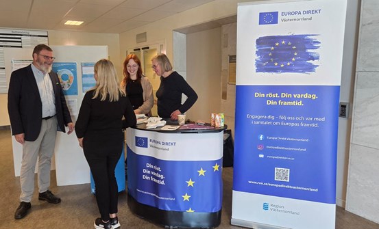 Fyra personer står och samtalar vid en Europa Direkt Västernorrland-monter.