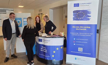 Fyra personer står och samtalar vid en Europa Direkt Västernorrland-monter.