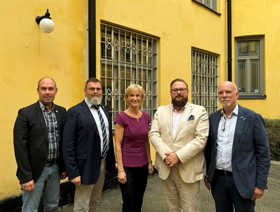 De fyra regionråden från norra Sverige står framför en gul byggnad tillsammans med  regeringens samordnare Kristina Alvendal.