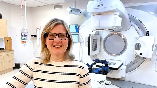 Sjukhusfysiker Ulrika Björeland framför en linjäraccelerator som finns på strålbehandlingen