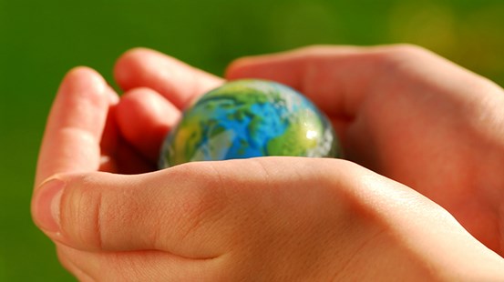 Händer av ett barn som håller en globe.
