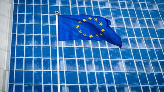 EU-flagga med ett höghus i bakgrunden