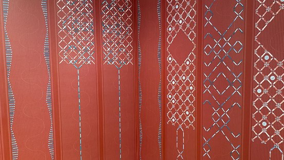 Ett mönster i röda, varma färger med inslag blå och vita toner av sprutor och sjukhusets täcken.