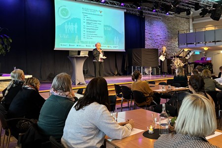 Ann-Marie pratar och inleder dagen från scenen inför åhörare.