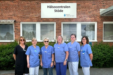 Sex personer står framför skylten med Stöde hälsocentral