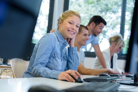 Studenter som sitter vid datorer och studerar. 
