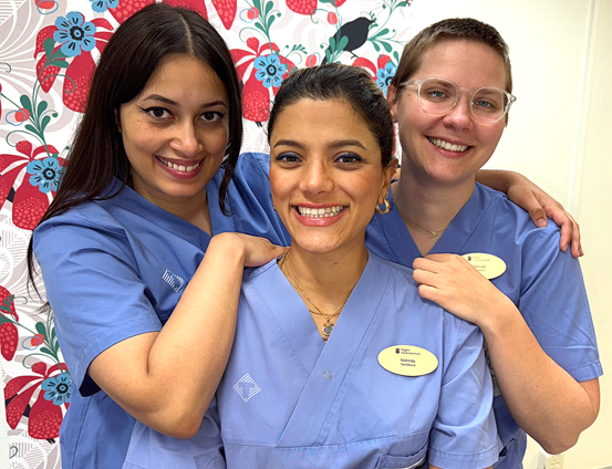 Porträttbild av tre glada, unga kvinnliga tandläkare i ett behandlingsrum på Folktandvården Centrum i Sundsvall.