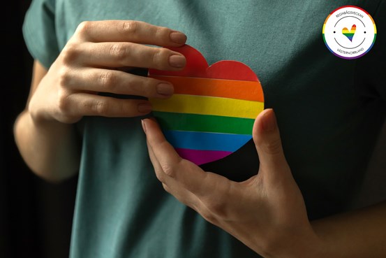 Händer som håller ett regnbågsfärgat hjärta 