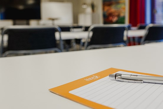 Penna och papper på ett bord i ett konferensrum
