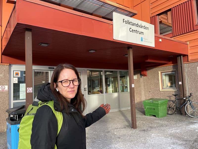 Enhetschef står framför byggnad som har skylt med text Folktandvården Centrum över entrén