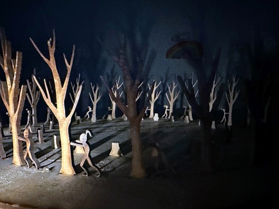 En tredimensionell zoetrop, en konstruktion som skapar en illusion av rörliga bilder. Svagt upplyst från ett håll syns en rund skiva med en scen som upprepas runt hela skivan. Scenen föreställer en flicka som försöker, outtröttligt, välta omkull ett stort träd. I bakgrunden kastas skuggor på väggarna i rummet.