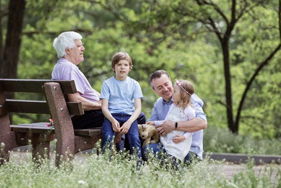Tre generationer träffas i en park.