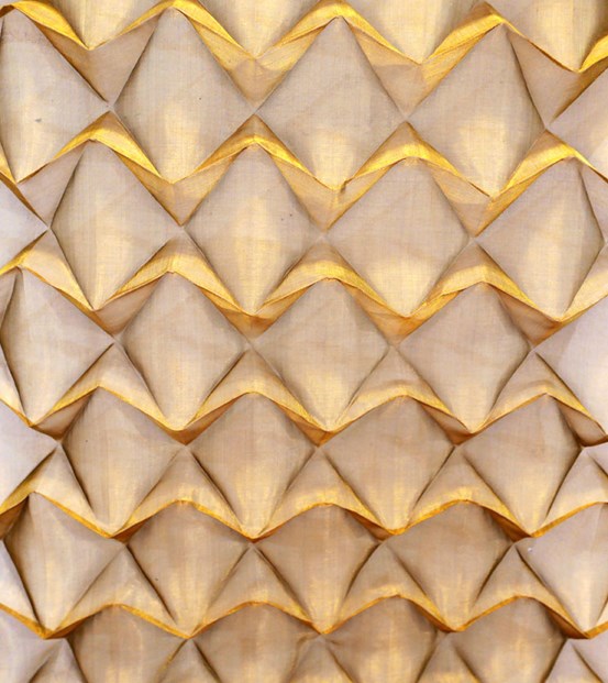 Ett rombliknande mönster bestående av vikt mässingsnät, färgerna går i mässing och beige. 
