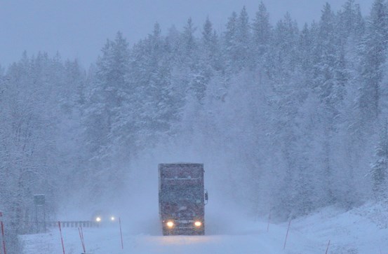 Lastbil som kör i snölandskap
