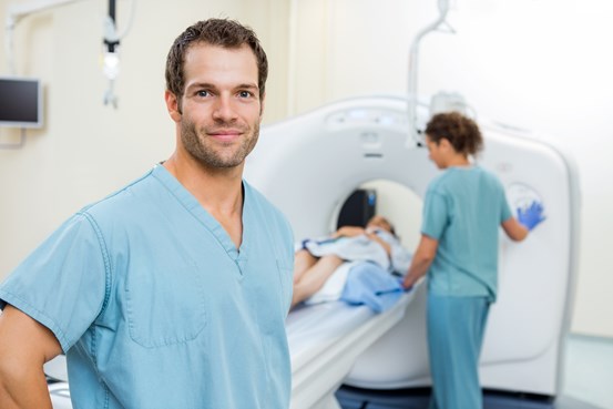 Vårdpersonal med patient som ska genomgå datortomografi