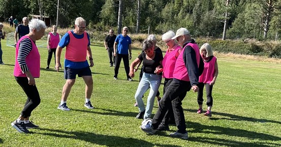Pensionärer i rosa västar spelar fotboll