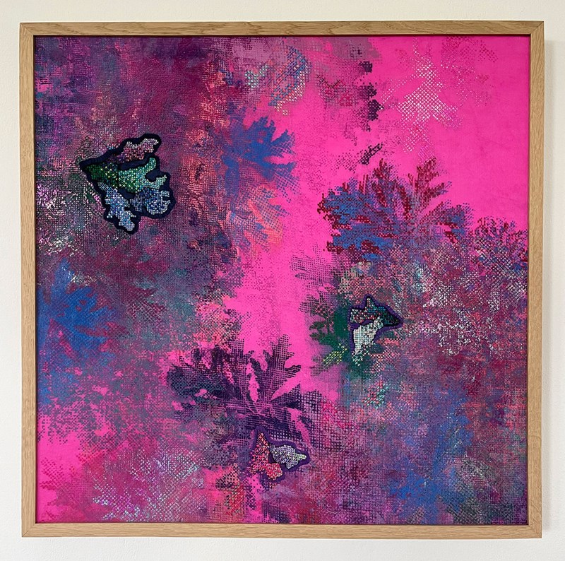 Ett kvadratiskt textilt verk inramat i träram. Verket ser ut som abstraherad växtlighet i mörkt rött, blått och lila. Bakgrunden är starkt rosa. 