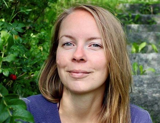 Tove Gulliksson fotograferad utomhus med grönskande bakgrund.