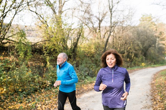 Äldre par joggar utomhus.