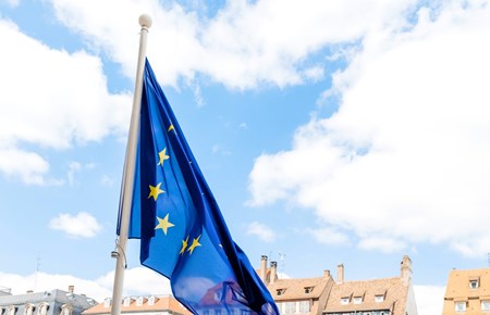 EU-flagga som vajar framför hustak