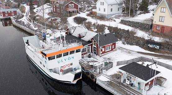Båten M/F Ulvön ligger förtöjd vid kajen  på Ulvön vintertid