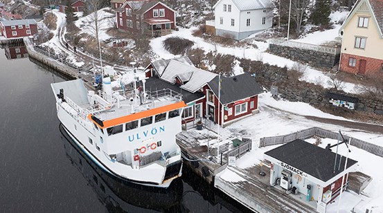 Båten M/F Ulvön ligger förtöjd vid kajen på Ulvön vintertid