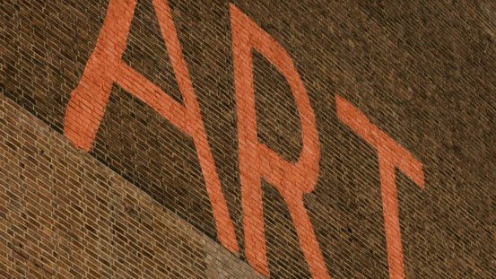 En röd tegelvägg med texten ART i röda versaler. 