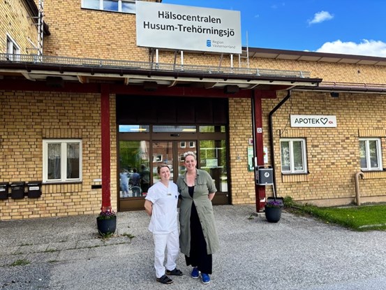 Två personer står framför hälsocentralens entré