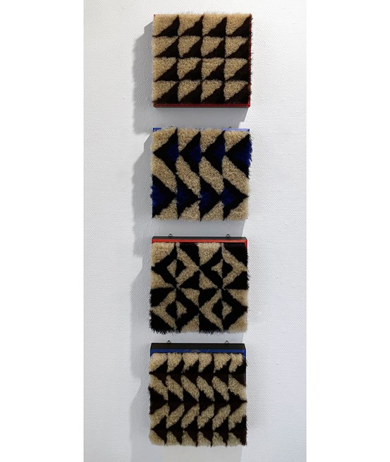 Fyra kvadratiska ramar med hästtagel tätt inuti, borstliknande med svartvita geometriska mönster.