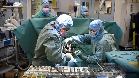 Operationssal med fyra medarbetare i arbete
