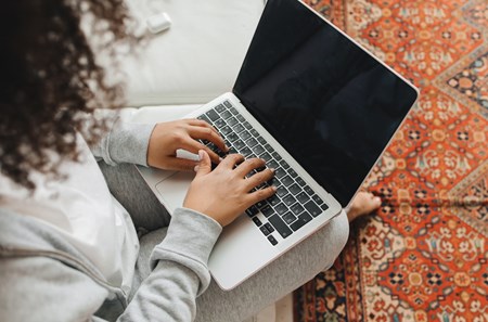 bild tagen ovanifrån på en person med lockigt hår som sitter vid en dator.