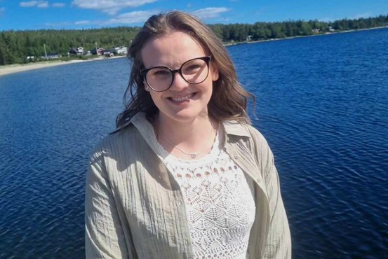 Anna Lundgren står framför en sjö och ler mot kameran.