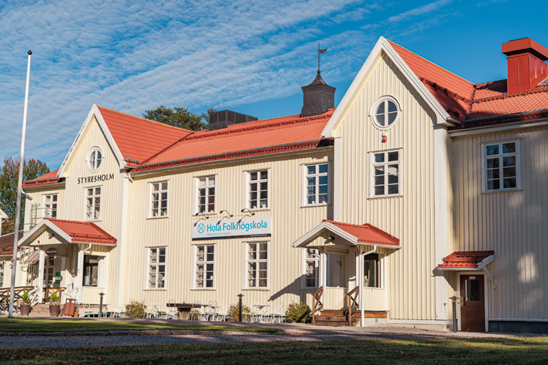 Hola folkhögskolas huvudbyggnad med en blå himmel bakom.