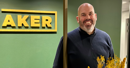 Tomas Falkensson, BizMaker står framför en grön vägg med texten BizMaker. 