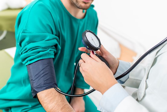 En doktor kontrollerar blodtrycket på en patient