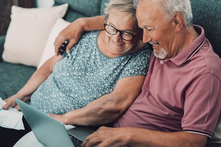 Ett äldre par framför en dator.