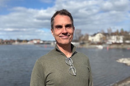 Porträtt av Stefan Nilsson utomhus vid vattnet.