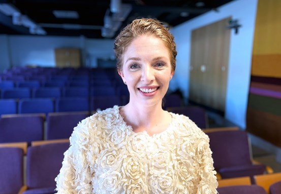 Porträttbild på specialisttandläkare Fanny Ellner i en föreläsningssal.