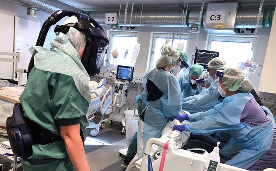 Sjukvårdspersonal i skyddsutrustning arbetar med covid-patient.